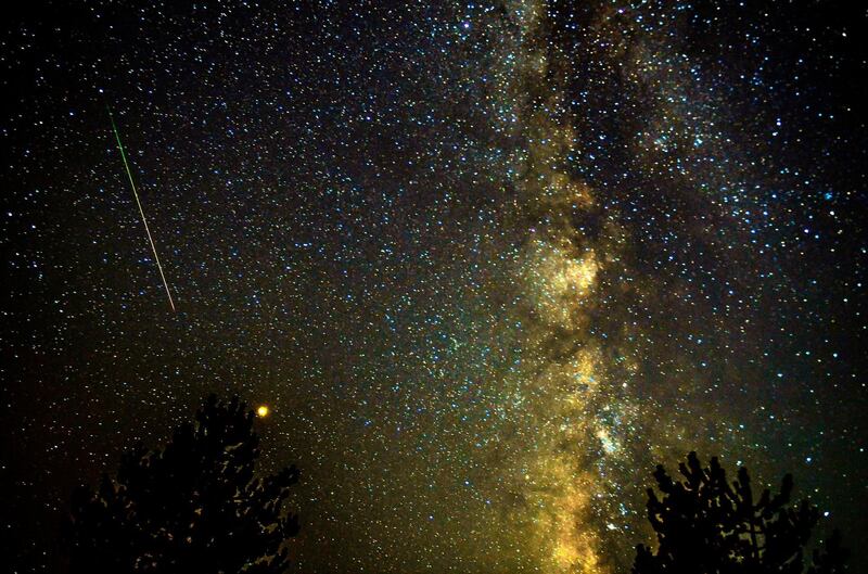 epa06947376 A meteor streaks through the night sky, past planet Mars (C, left), during the Perseid meteor shower over the lake of Kozjak, some 45km from the capitol Skopje, the Former Yugoslav Republic of Macedonia, 13 August 2018.  EPA/GEORGI LICOVSKI
