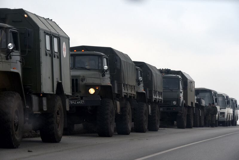 Russian military trucks and buses are seen on the side of a road in Russia's southern Rostov region, which borders the self-proclaimed Donetsk People's Republic, on February 23, 2022. AFP