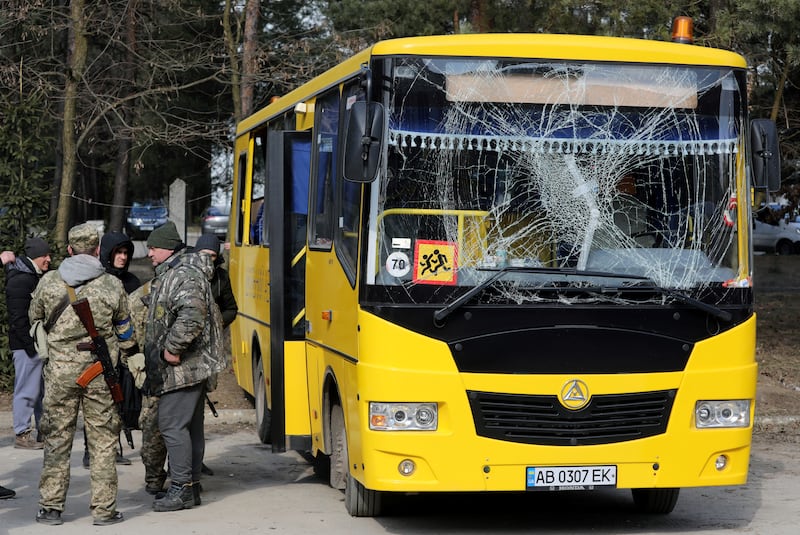Soldiers stand next to a bus with a damaged windscreen, after an attack on the Yavoriv military base, in Novoyavorivsk, Ukraine. Reuters