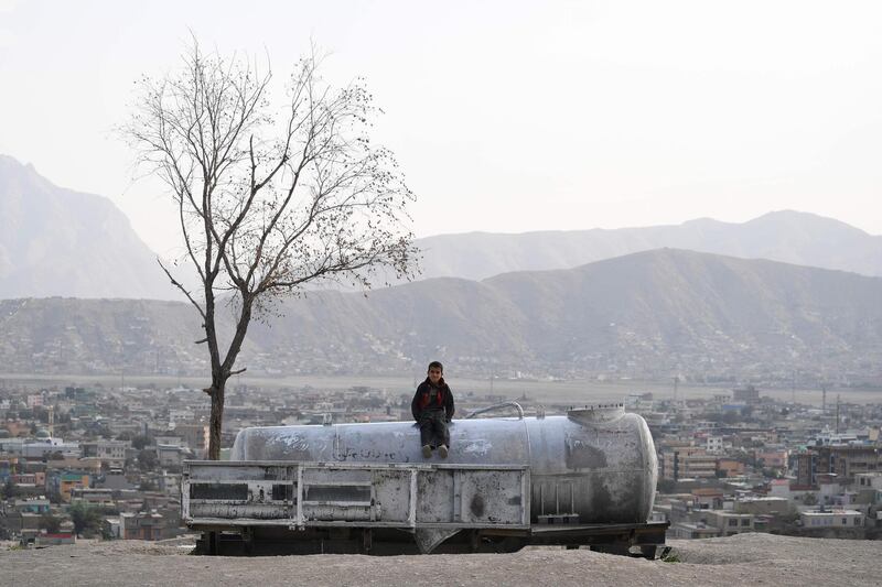 An Afghan child sits on a water tank at Nadir Khan hill in Kabul.  AFP