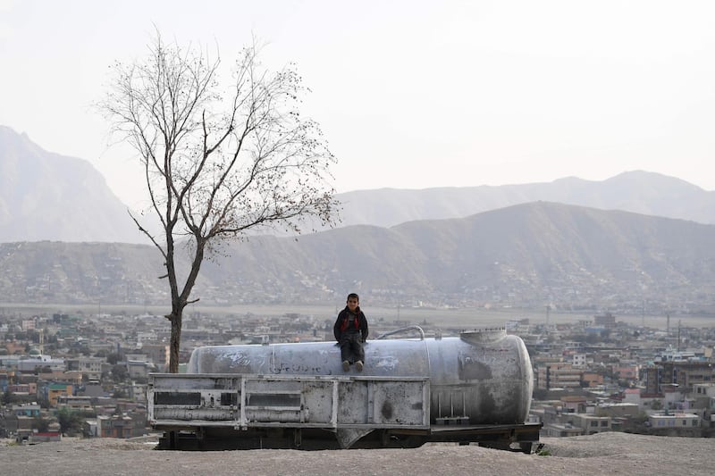 An Afghan child sits on a water tank at Nadir Khan hill in Kabul.  AFP