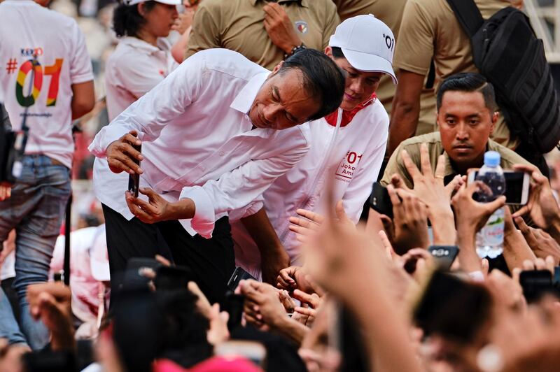 Indonesian President Joko Widodo, popularly known as Jokowi, poses for a selfie with supporters at a rally at Jakarta's main stadium on April 13, 2019. Getty Images