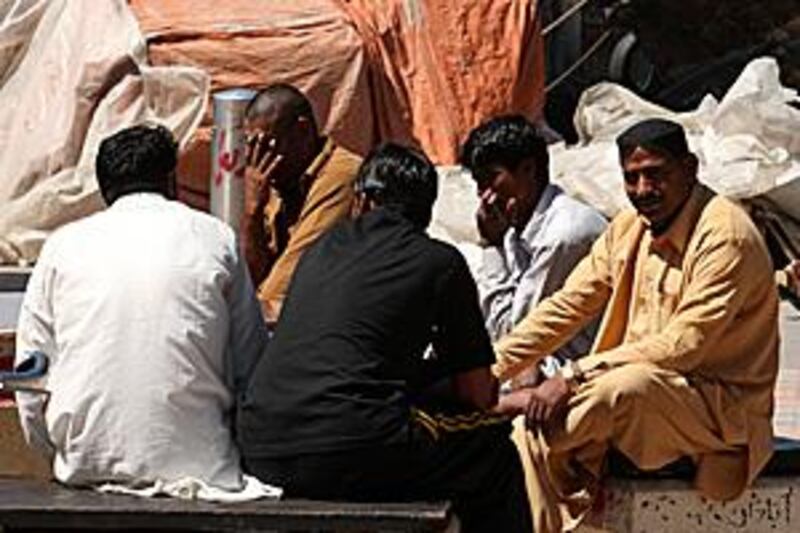 Dhow workers mingle during their lunch break yesterday.