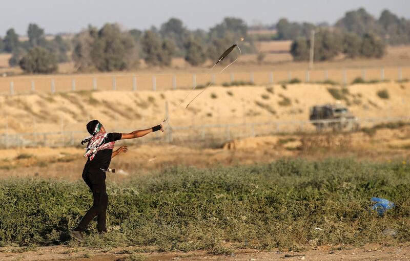 An Palestinian protester uses a slingshot to hurl stones at Israeli forces on the Gaza-Israeli border  east of Khan Yunis in the southern Gaza Strip. AFP