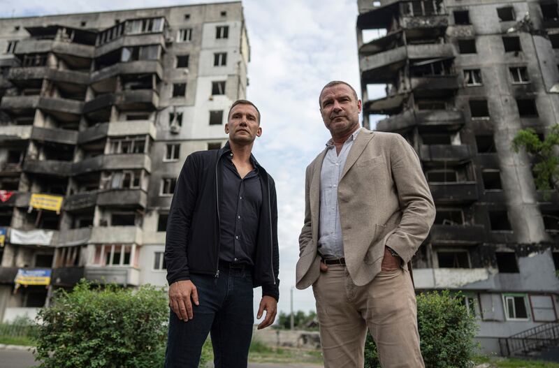 Former Ukraine footballer Andriy Shevchenko and American actor Liev Schreiber stand surrounded by destroyed buildings in Borodianka, near Kyiv. AP