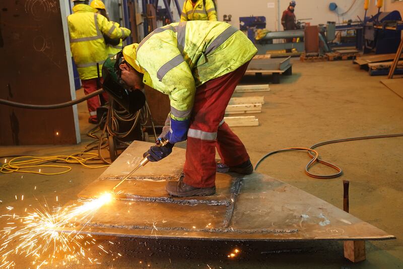 A welder at Harland & Wolff shipyard in Belfast. Much of the downward pressure on input prices came from a widespread fall in raw material costs. PA