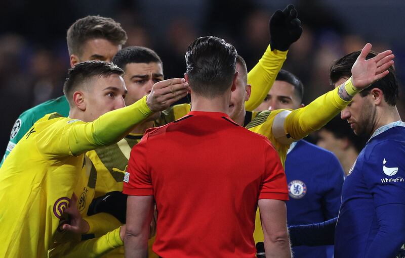 Dortmund players surround Referee Danny Makkelie after he deemed ruled that Chelsea could re-take their penalty. AFP