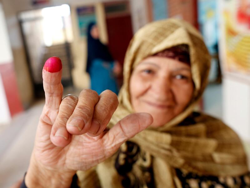 An Egyptian voter displays her inked finger after she cast her ballot on constitutional amendments during the second day of three-day voting at a polling station in Cairo, Egypt. AP Photo