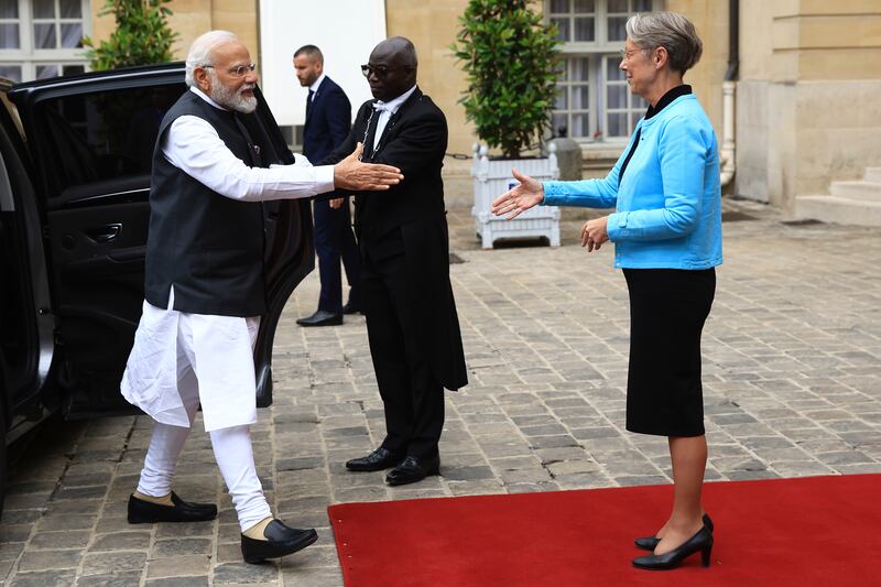 The Indian Prime Minister is greeted by his French counterpart before joining Bastille Day celebrations. AP