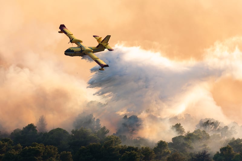 A plane dumps water over a wildfire on Ciovo island, Croatia. AP