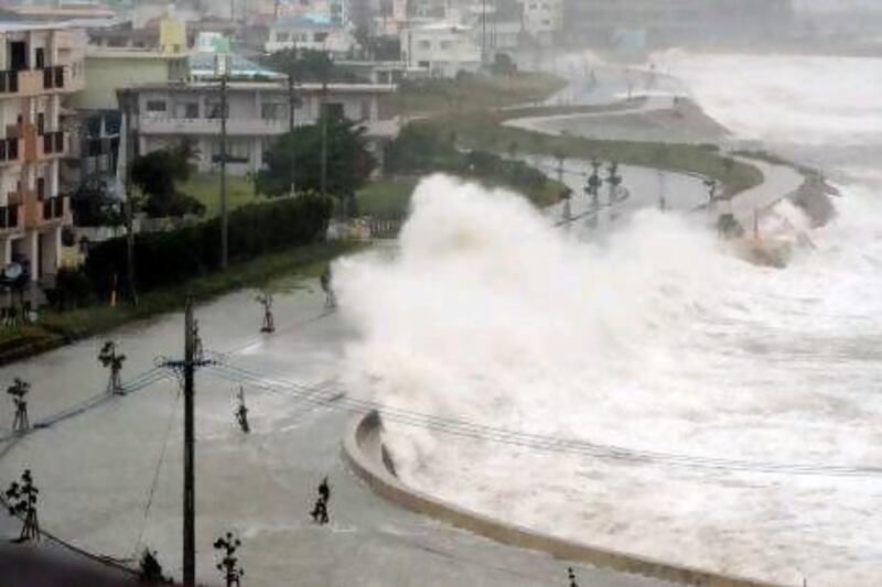 High waves pound the seawall in Yonabarucho, Okinawa. Residents were warned to stay indoors and that wind gusts could overturn cars and cause waves of up to 12 metres.