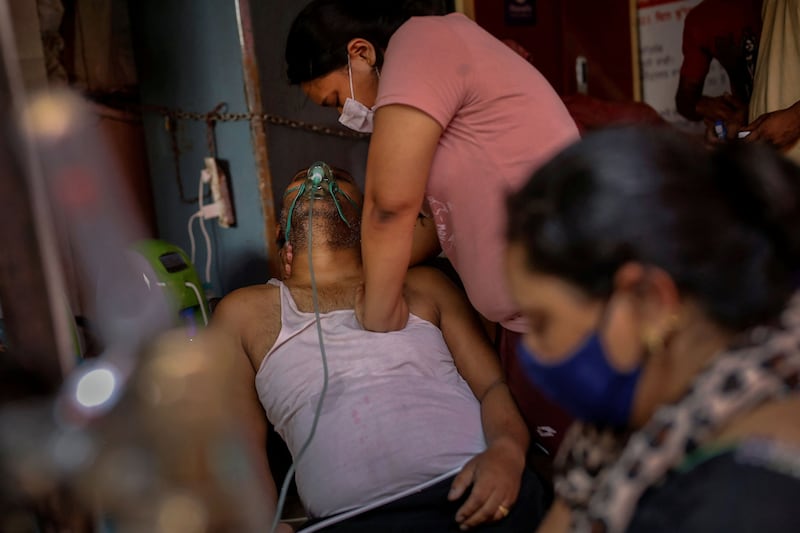 Manisha Bashu presses the chest of her father, who was having difficulty breathing, after he became unconscious while receiving oxygen support amid the spread of coronavirus disease in Ghaziabad, India, on April 30, 2021.  By Adnan Abidi,  Pulitzer Prize Winner for Feature Photography. Reuters