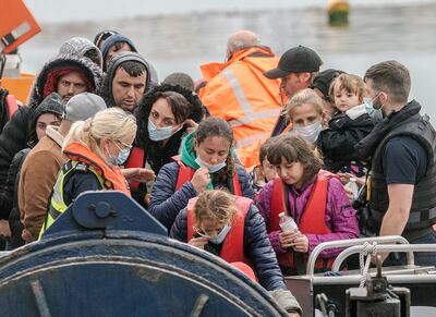 Border Force officials escort migrants ashore at Dover.  EPA