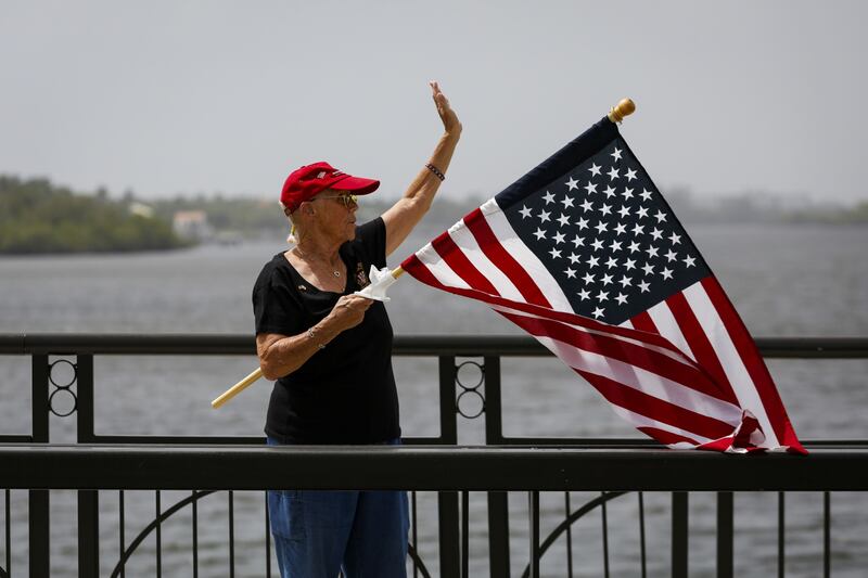 A Trump supporter waves a flag outside Mar-a-Lago. Bloomberg