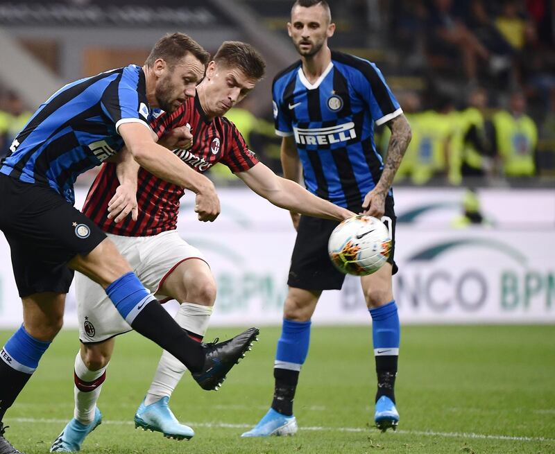 Inter Milan's Dutch defender Stefan de Vrij and AC Milan's Polish forward Krzysztof Piatek go for the ball. AFP