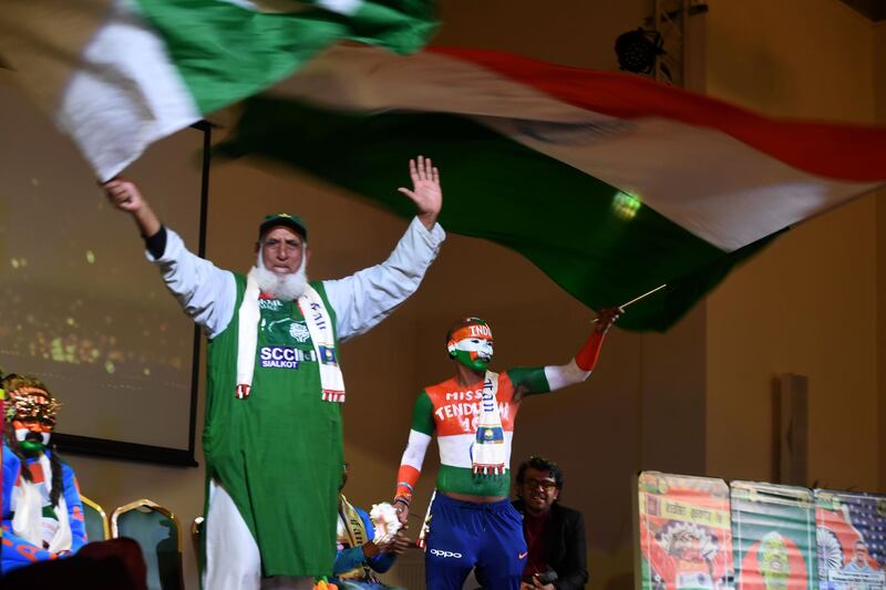 Pakistan cricket fan "Chacha Cricket", AKA Chacha Sufi Jalil (L) and Indian cricket fan Sudhir Gautam wave flags at a super-fan event in Manchester on June 14, 2019, ahead of the India v Pakistan 2019 World Cup cricket match. 
 / AFP / Dibyangshu SARKAR
