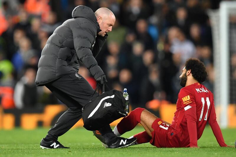 Mohamed Salah is seen to by a medic after hurting his left ankle against Tottenham. AFP