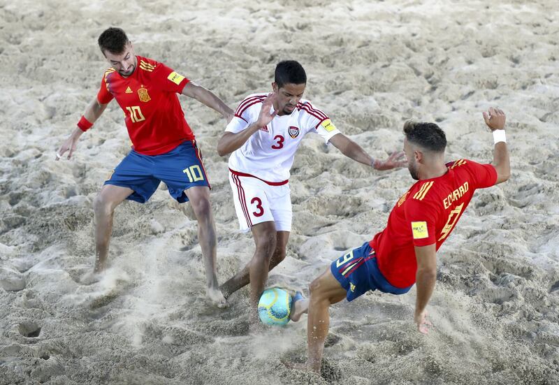 Dubai, United Arab Emirates - November 05, 2019: The UAE's Ahmed Bashr and Spain's Llorenc Gomez Leon (L) with Eduard Suarez Molina (R) battle during the game between the UAE and Spain during the Intercontinental Beach Soccer Cup. Tuesday the 5th of November 2019. Kite Beach, Dubai. Chris Whiteoak / The National