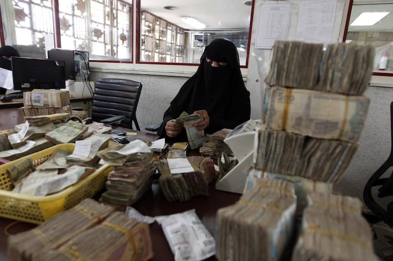 An employee counts stacks of Yemeni currency at Yemen's central bank in Sanaa on August 25, 2016, ahead of the government's decision to relocate the facility to Aden. The Yemeni government accuses Houthi rebels of spending foreign currency reserves on their war effort. AFP PHOTO / MOHAMMED HUWAIS