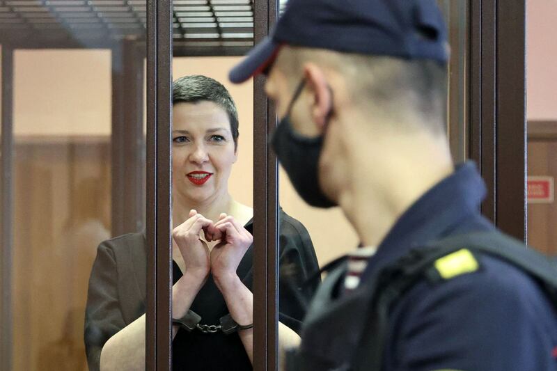 Maria Kolesnikova gestures making a heart shape inside the defendants' cage during her verdict hearing on September 6, 2021, in Minsk. AFP