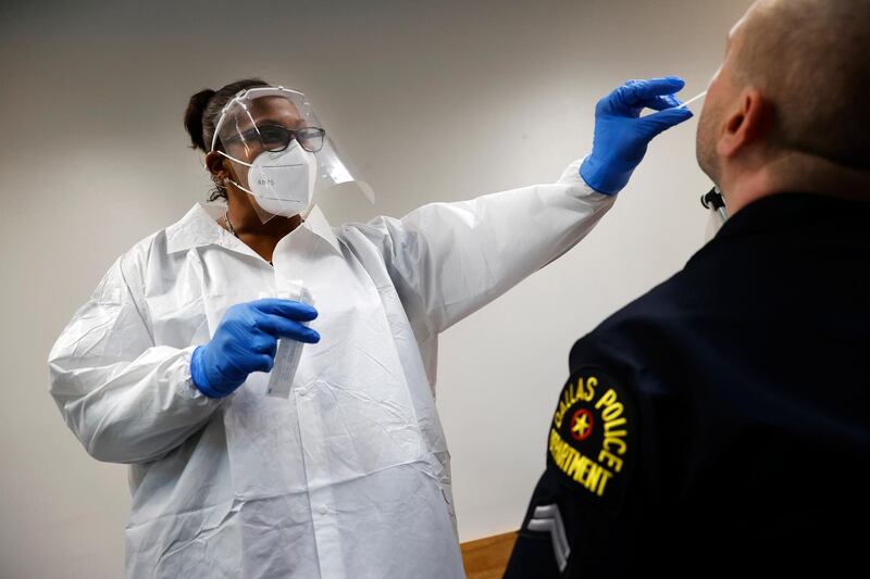 A Dallas police officer is tested for Covid-19 by SafeWork medical assistant Joanna Jackson at the Dallas Police Association office. AP Photo
