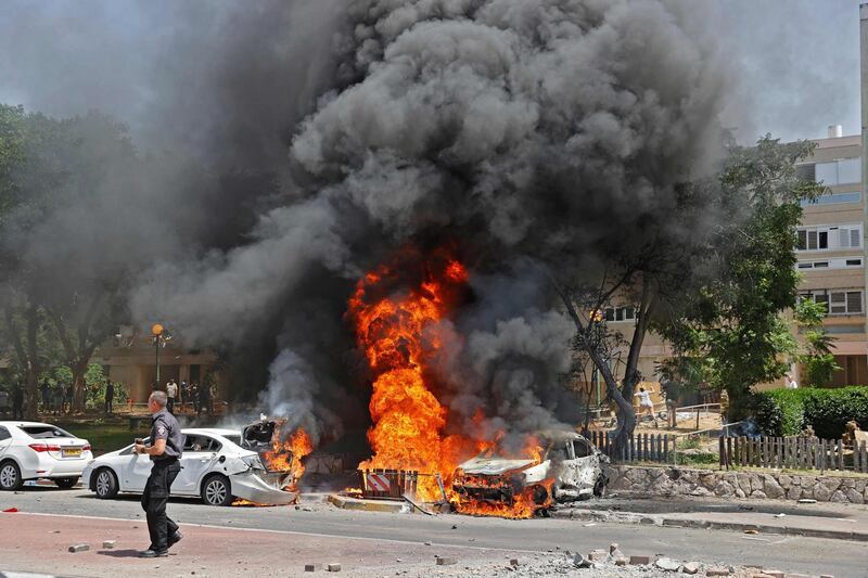 Vehicles are set ablaze after a rocket launched from the Gaza Strip lands in Israeli city Ashdod. AFP