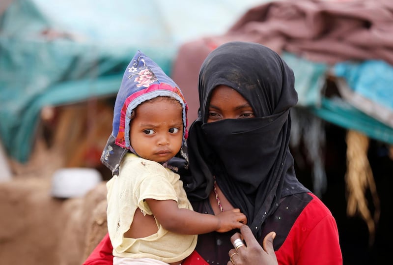 A girl carries a child near a hut in an improvised camp for internally displaced people near Abs of the northwestern province of Hajja, Yemen February 18, 2019. Picture taken February 18, 2019. REUTERS/Khaled Abdullah
