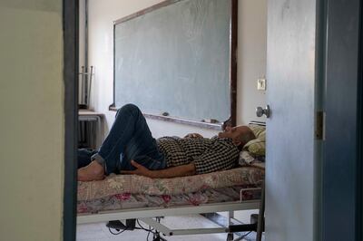 A man sleeps in a classroom that has been repurposed as a displacement centre in southern Lebanon. Matt Kynaston / The National