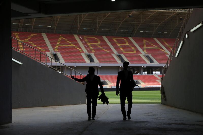 Two men walk inside the Karbala Olympic Stadium in Karbala, central Iraq, on April 4, 2018.
Baghdad's Al-Zawra will face off against Beirut's Al-Ahed on April 10, in Iraq's first hosting of an international match following the lifting of a FIFA ban. / AFP PHOTO / Mohammed SAWAF