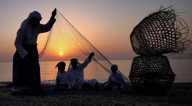 Emirati fishermen set up nets on the shore off the coast of Dalma island in the Gulf, near the Emirati capital Abu Dhabi on May 21, 2021. / AFP / Karim SAHIB
