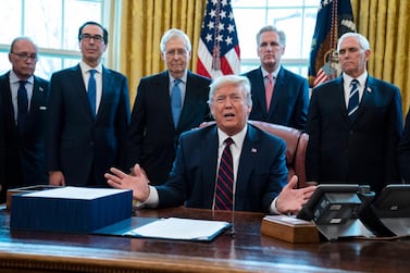 President Donald Trump signs the coronavirus stimulus relief package in the Oval Office at the White House. AP Photo/Evan Vucci