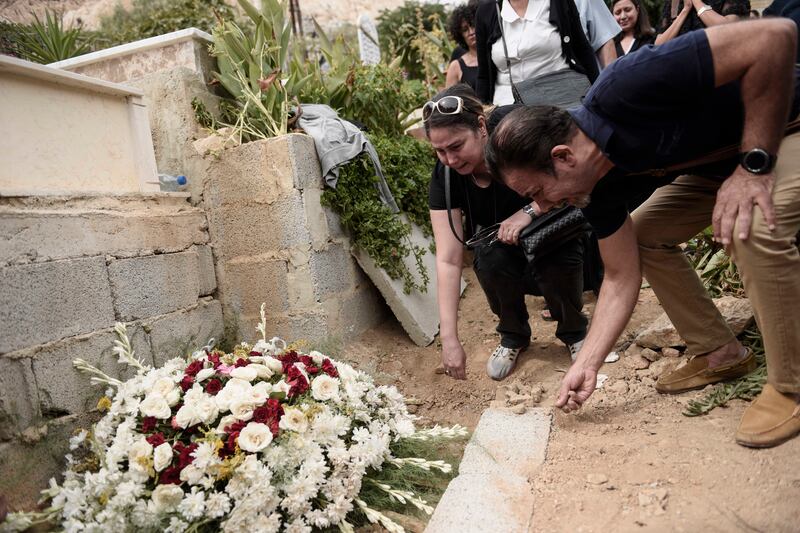 Mourners pay their respects to the Syrian novelist at the Taghaleb martyrs cemetery, in Al-Muhajreen district