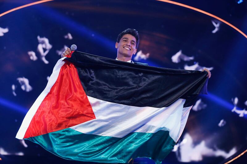 Palestinian singer Mohammed Assaf holds the Palestinian flag, as he stands on stage after being announced winner during the Season 2 finale of "Arab Idol" in Zouk Mosbeh area, north of Beirut June 22, 2013. REUTERS/Mohammed Azakir (LEBANON - Tags: ENTERTAINMENT TPX IMAGES OF THE DAY) *** Local Caption ***  LBN04_LEBANON-_0622_11.JPG