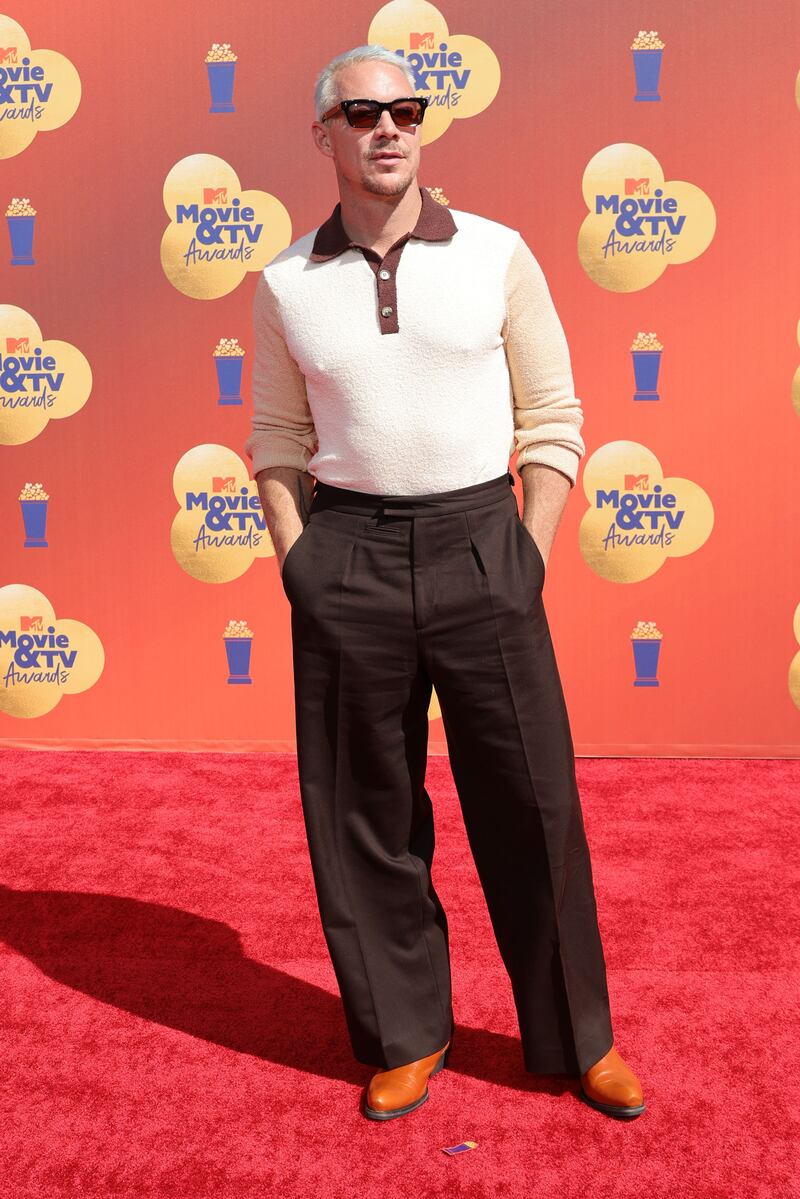 Diplo wearing a maroon-collared polo and wide-legged trousers. AFP