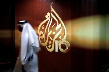 A employee of Al Jazeera walks past the Qatari' broadcaster's logo at its offices in Doha, Qatar. AP Photo