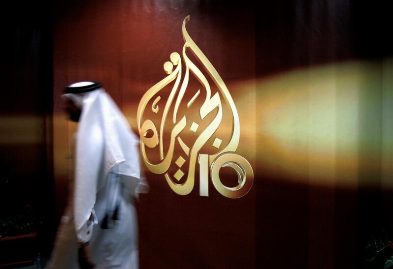 FILE - In this Nov. 1, 2006 file photo, a Qatari employee of Al-Jazeera Arabic language TV news channel walks past the logo of Al-Jazeera in Doha, Qatar. An Egyptian court on Thursday, May 23, 2019, ordered the release of an Al-Jazeera journalist who had been detained since 2016 on allegations of spreading false news and defaming Egyptâ€™s reputation. Mahmoud Hussein, an Egyptian journalist working for the Qatar-based satellite network, was detained at the Cairo airport in December 2016 when he arrived on a family vacation from Doha. No official charges were ever raised against him and Hussein didnâ€™t stand trial.   (AP Photo/Kamran Jebreili, File)