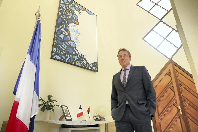 ABU DHABI , UNITED ARAB EMIRATES , JULY 8 – 2018 :- Ludovic Pouille , Ambassador of France posing for the photo with the painting made by El Seed at his residence in Abu Dhabi. ( Pawan Singh / The National )  For News. Story by John