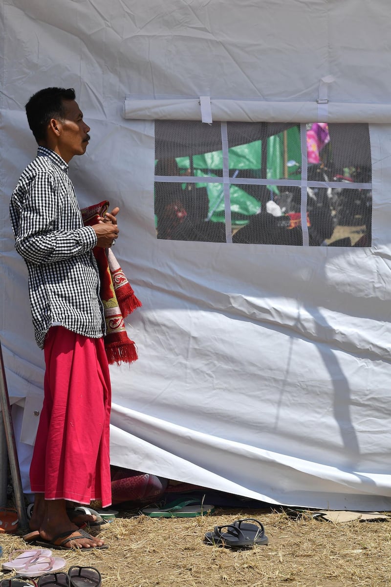 An Indonesian Muslim man attends congregational Friday prayers on a field near temporary shelters in Pemenang, northern Lombok.  AFP