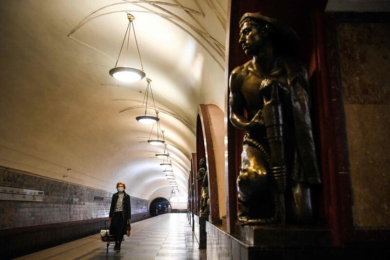 A passenger wearing a protective mask walks on a platform at a metro station in Moscow.  AFP