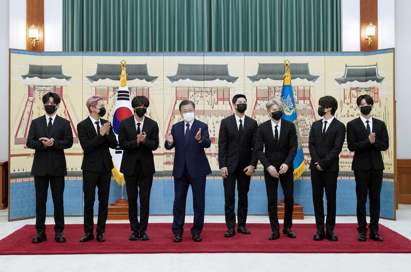 This picture taken on September 14, 2021 shows South Korean President Moon Jae-in (4th L) posing with members of K-pop sensation BTS as they receive diplomatic passports for a UN session as presidential special envoys at the presidential Blue House in Seoul.  (Photo by -  /  YONHAP  /  AFP)  /  - South Korea OUT  /  REPUBLIC OF KOREA OUT  NO ARCHIVES  RESTRICTED TO SUBSCRIPTION USE