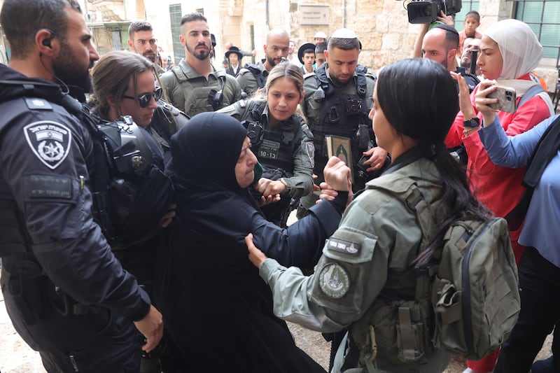 Police push back a Palestinian woman protesting near Orthodox Jews celebrating Sukkot in the Old City of Jerusalem. EPA