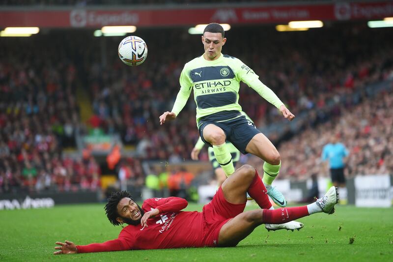 Liverpool defender Joe Gomez slides in on Phil Foden of Manchester City. Getty