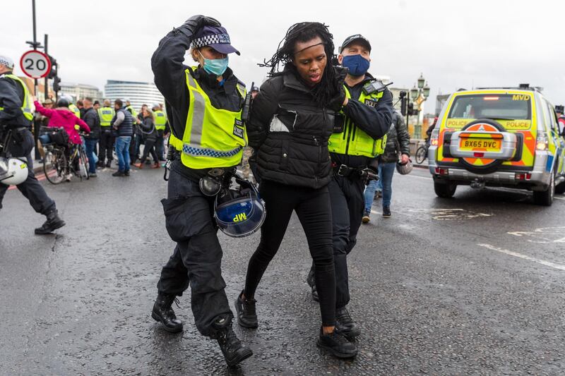 An anti-lockdown protester is lead away by police after being restrained during a demonstration against lockdown measures in Westminster, London.  EPA