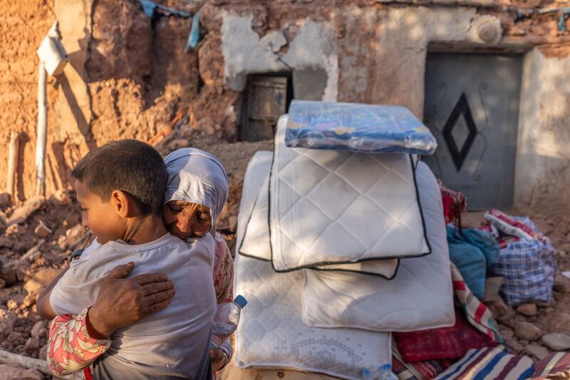 A woman comforts a child outside a destroyed house in Tafeghaghte, in El Haouz region. Bloomberg