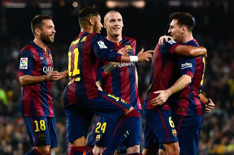 Lionel Messi celebrates with teammates after scoring the team's first goal against Sevilla on Saturday night in La Liga, with the tally bringing him level with Telmo Zarra's Liga goalscoring record, which he would later surpass. David Ramos / Getty Images