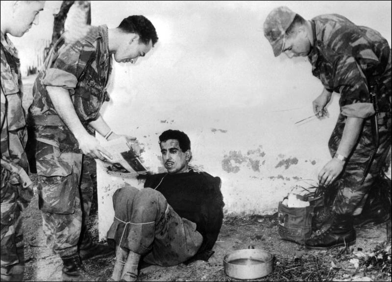 (FILES) In this file photo taken on March 14, 1957 French paratroopers question Algerian Omar Merouane in Saint Eugene.

 French president Emmanuel Macron appointed expert historian Benjamin Stora to work on a report on the Algerian war and Colonisation memoir, a still burning issue, as the 60th anniversary of the independence of Algeria (1962) approaches. The report will be submitted on January 20, 2021. / AFP / INTERCONTINENTALE / Jacques GREVIN
