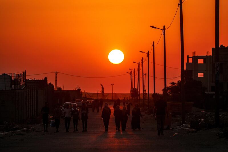 Palestinian refugees walk in the street during sunset in the refugee camp of Khan Younis in the southern Gaza Strip.  EPA