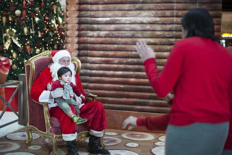 AJ Liouigan, seven months old, looks on as his parents try to get him to smile for a photograph with Santa at Abu Dhabi Mall. Mona Al Marzooqi/ The National