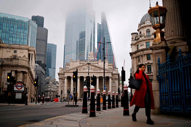 A pedestrian walks near the Royal Exchange and the Bank of England in the City of London on the bank holiday, December 28, 2020, as Londoners continue to live under Tier 4 lockdown restrictions. Business breathed a sigh of relief this week after a post-Brexit trade deal was agreed, but many issues remain unresolved, notably the place of financial services, which represent 80 per cent of the British economy, as the newly inked deal focuses on trade in goods. / AFP / Tolga Akmen
