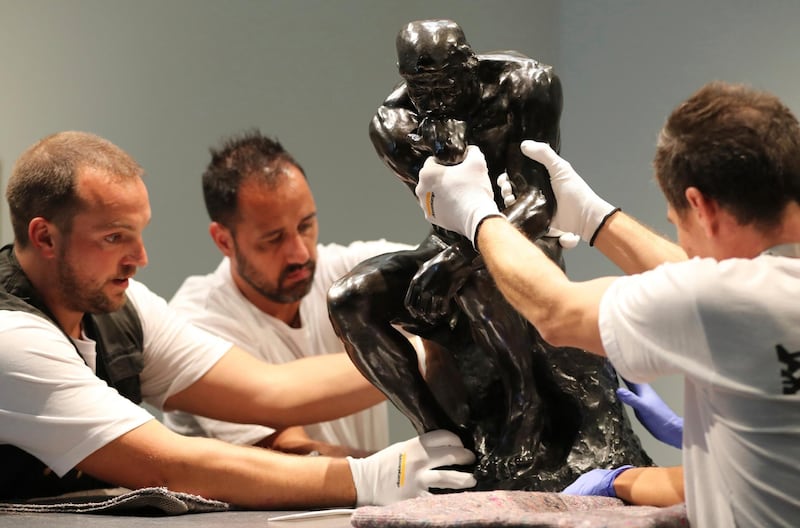 Staff members move Rodin's 'The Thinker' bronze statue during installation at the Louvre Museum in Abu Dhabi. Kamran Jebreili / AP photo
